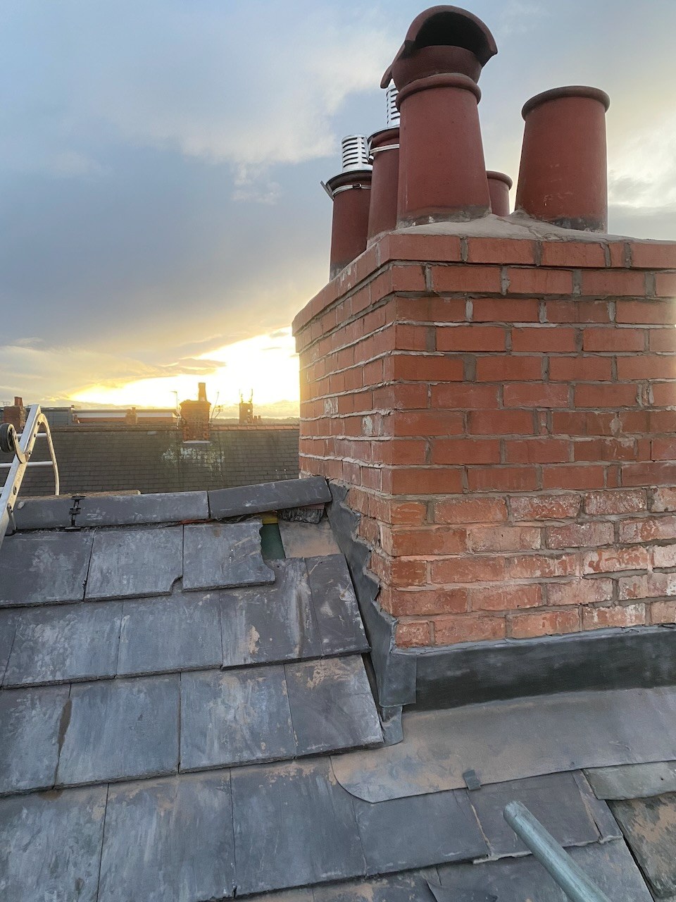 Rebuilt brick chimney with pots and lead flashing during the Dinmore Road roof replacement in Wallasey