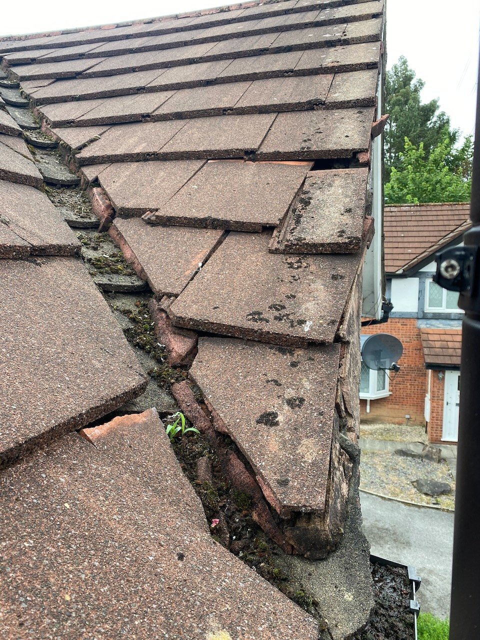 Before: deteriorated roof valley with debris and vegetation in Halewood